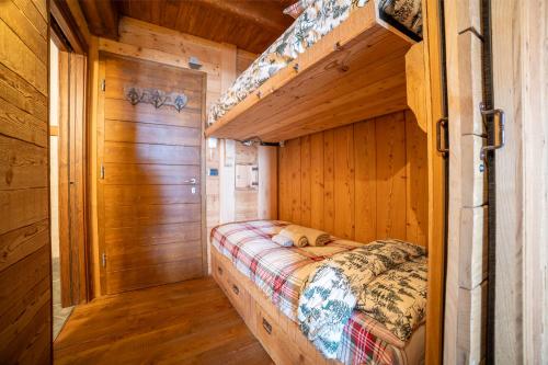 a bed in a room with wooden walls at Chalet sulle piste da sci con Garage a Limone 1400 in Limone Piemonte
