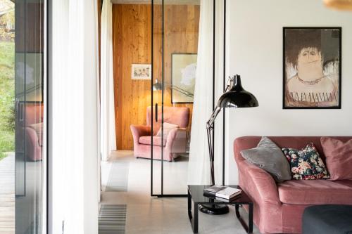 a living room with a pink couch and a lamp at Proste Chwile in Tylicz