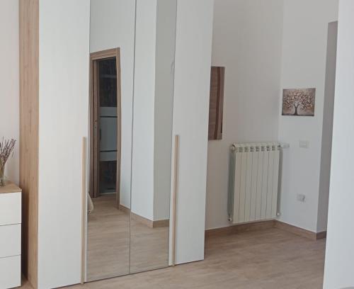 a room with white walls and a mirror at B&B Phoenix in Torre del Greco