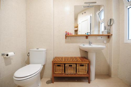 ein Badezimmer mit Toilette, Waschbecken und Spiegel in der Unterkunft Atico Brisa in Cádiz