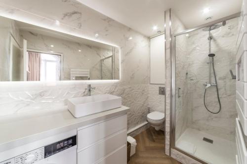 a white bathroom with a sink and a shower at Le Chalet climatisé du 6ème in Lyon