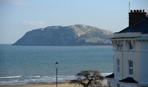 a building on the beach with a mountain in the background at The Cumberland in Llandudno