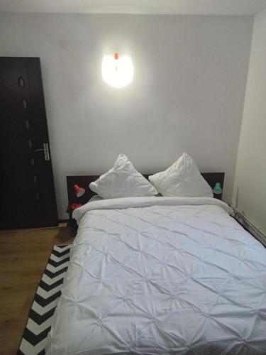 a bedroom with a bed with white sheets and pillows at Casa Ozon in Vulcan