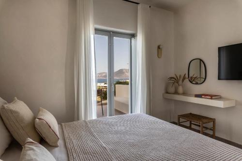 a bedroom with a bed and a view of the ocean at Nysis Koufonisia in Koufonisia