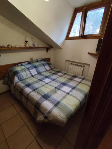 a bedroom with a bed with a plaid blanket at Chalet Elegante - Campo Felice e Piste da scii in Spogna