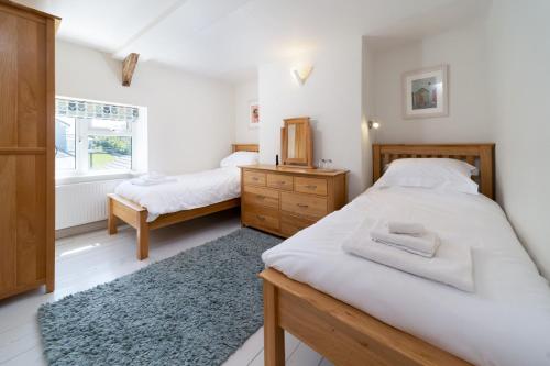 ein Schlafzimmer mit zwei Betten und einem Fenster in der Unterkunft Ford Hill Cottage in East Down