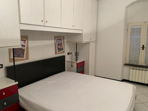 マリーナ・ディ・カッラーラにあるCasa Giuntiniのベッドルーム(ベッド1台、白いキャビネット付)