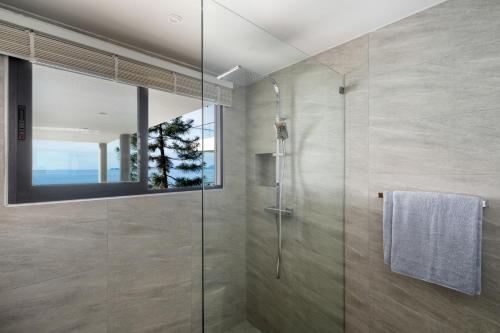 a bathroom with a shower with a glass door at The Penthouses, Bangpor Seaview Luxury Apartment in Koh Samui 