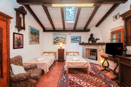 un soggiorno con 2 letti e un camino di Apartment Samblich Atelier a Krk