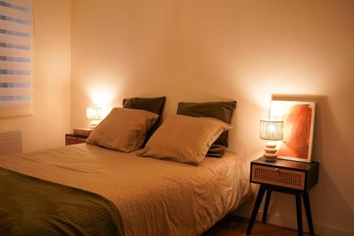 une chambre avec un lit avec deux lampes dessus dans l'établissement T2 cosy au cœur de Perpignan, à Perpignan