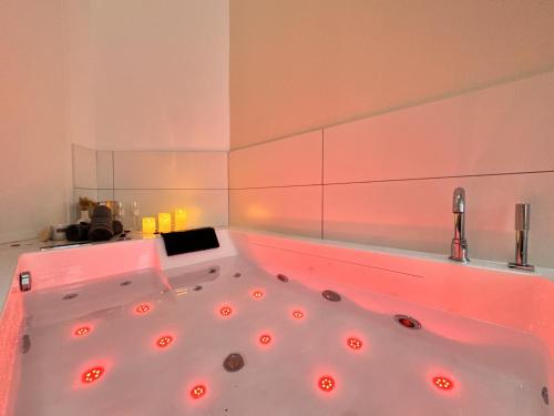 a bathroom with a tub with red lights in it at Mon spa privé - Balnéo & Sauna - Le Mans insolite in Le Mans