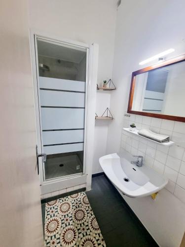 une salle de bain blanche avec une douche et un lavabo dans l'établissement Jolie villa 4 chambres, à Martigues