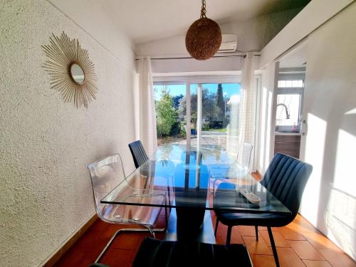 une salle à manger avec une table et des chaises en verre dans l'établissement Jolie villa 4 chambres, à Martigues