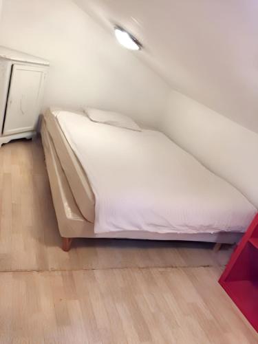 Ce lit se trouve dans un dortoir doté d'un mur blanc. dans l'établissement Appartement charmant à Roanne, terrasse, à Roanne