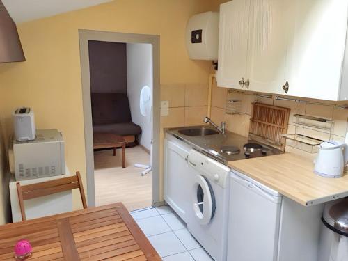a kitchen with a sink and a washing machine at Appartement charmant à Roanne, terrasse in Roanne