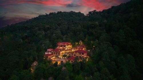 a house on a hill in the middle of a forest at The Chumbi Mountain Retreat & Spa, A Club Mahindra Associate in Pelling