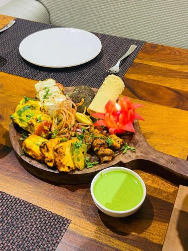 a plate of food on a wooden table with green sauce at Yashvrinda in Mandor