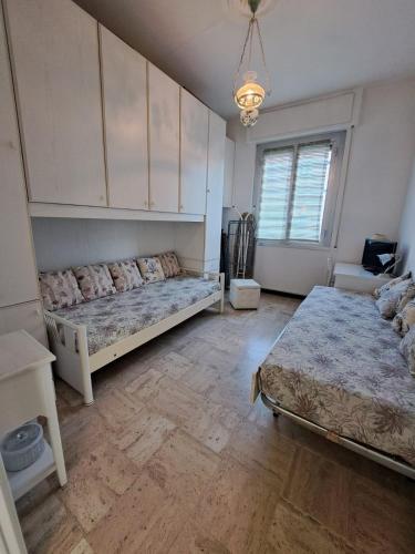 Un dormitorio con dos camas y una lámpara de araña. en CASA GAIA, pet friendly with terrace, en Rapallo