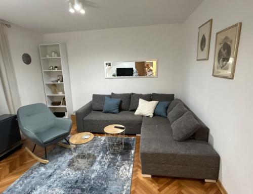 a living room with a gray couch and a blue chair at Dorotea Lux in Belgrade
