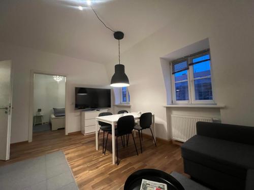 a living room with a table and chairs and a television at Gemütliche Wohnung im Zentrum. in Bayreuth