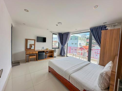 a bedroom with a bed and a large window at Đà Lạt Cao Nguyên Hotel in Da Lat
