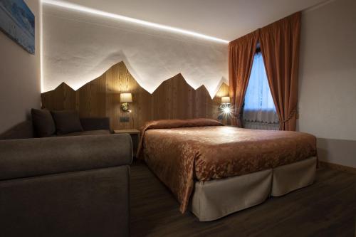 a bedroom with a bed and a couch at Hotel Des Glaciers in Courmayeur