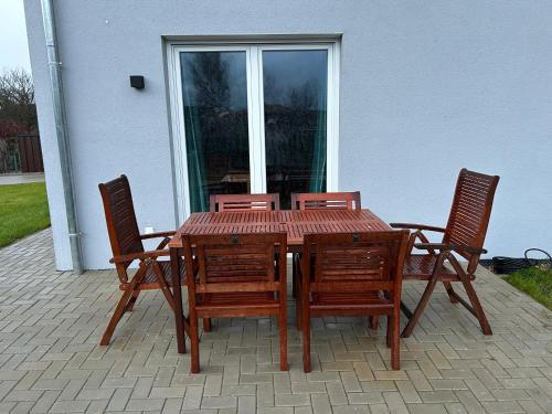 a wooden table with four chairs and a window at Ferienwohnung Südstraße in Eschede