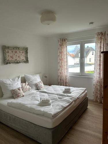 a white bed in a bedroom with a window at Ferienwohnung Südstraße in Eschede