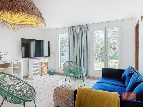 un salon avec un canapé bleu et des chaises dans l'établissement Au Ptit Bouchon Villa Golf, à Wimereux