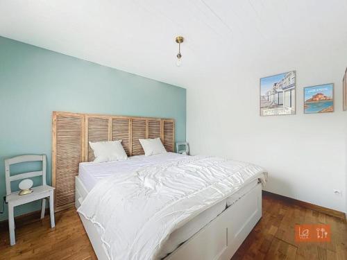 une chambre avec un grand lit avec des draps blancs dans l'établissement Au Ptit Bouchon Villa Golf, à Wimereux