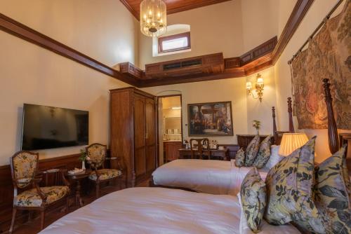 a bedroom with two beds and a flat screen tv at Cecil by Pearl Continental in Murree