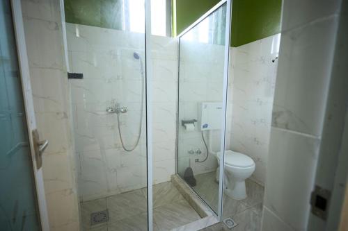 a bathroom with a shower and a toilet at AMP Lodge in Kumasi
