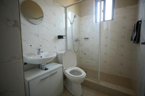 a bathroom with a toilet and a sink and a shower at AMP Lodge in Kumasi