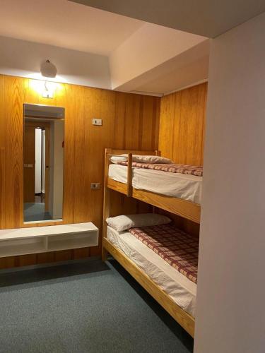 a room with two bunk beds and a mirror at Residence Solaria, Albarè, Marilleva 1400 in Marilleva