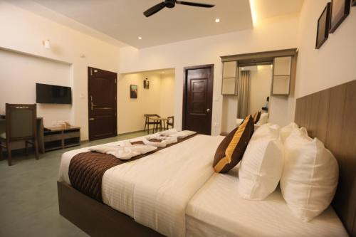 a bedroom with a large bed in a room at Holidays Garden Resort in Kalpetta