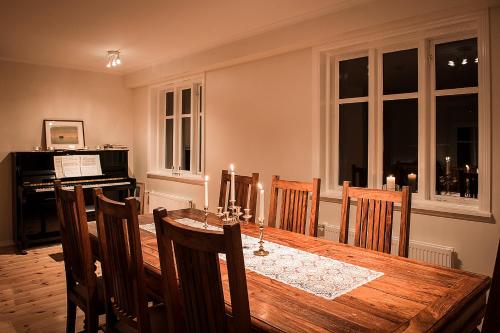 a dining room with a table and a piano at Kolkuós Guesthouse in Kolkuós 