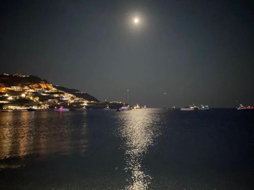 a moon over a body of water at night at Elysia House in Ornos