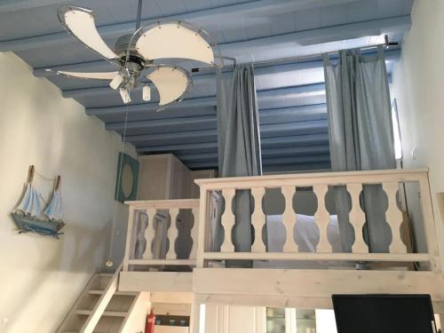 a ceiling fan and a staircase in a room at Elysia House in Ornos