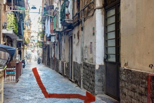 an alley with an orange arrow on the side of a building at Seventeen Home in Naples