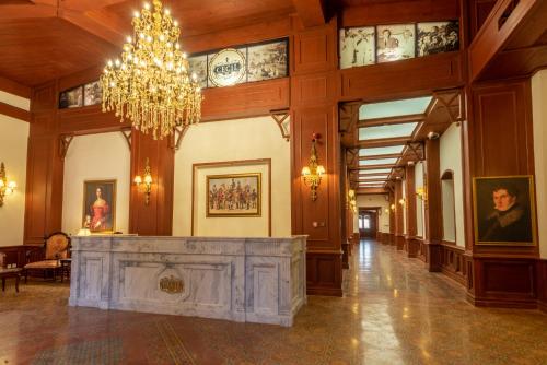 a large lobby with a chandelier and a fireplace at Cecil by Pearl Continental in Murree