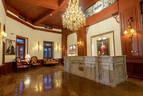 a large room with a chandelier and a fireplace at Cecil by Pearl Continental in Murree