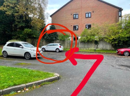 a red ribbon on a street with parked cars at 2 Bedroom Flat Bracknell Free Parking in Bracknell