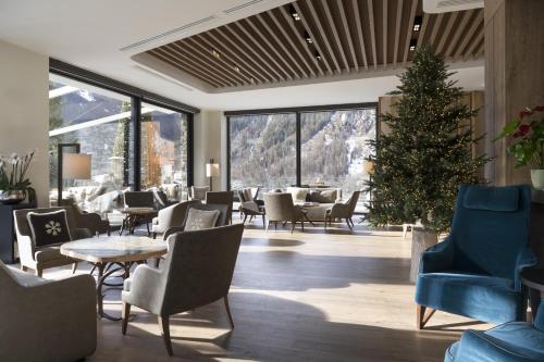 a lobby with chairs and a christmas tree in a room at Grand Hotel Courmayeur Mont Blanc, by R Collection Hotels in Courmayeur
