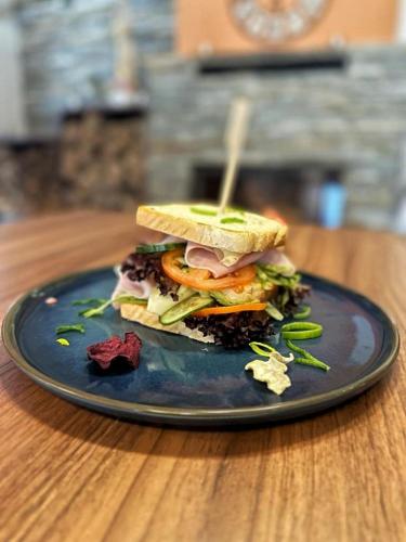 a sandwich on a blue plate on a table at Restaurace a penzion Lutena in Dolní Lutyně