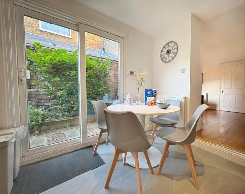 a dining room with a table and chairs and a window at Artsy & bright Hammersmith London 1b1b, up to 4 people in London