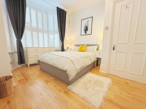 a bedroom with a bed and a rug and a window at Artsy & bright Hammersmith London 1b1b, up to 4 people in London