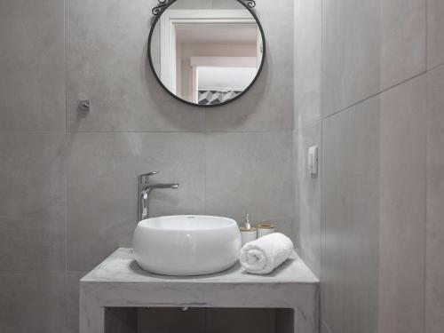 a bathroom with a sink and a mirror at Chris & Jo Villas, Enchanting Escapes, with Heated Pools & SeaViews By ThinkVilla in Zakynthos Town