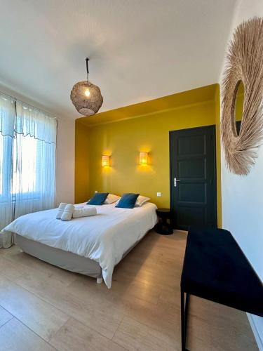- une chambre avec un grand lit et un mur jaune dans l'établissement Casa Labrunie - Central T3 avec Garage et Grande Terrasse, à Brive-la-Gaillarde