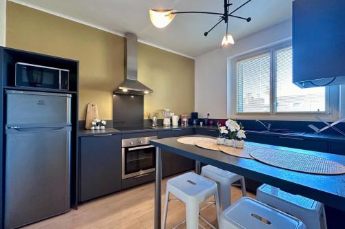 une cuisine avec une table et un réfrigérateur dans l'établissement Casa Labrunie - Central T3 avec Garage et Grande Terrasse, à Brive-la-Gaillarde