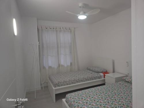 una camera da letto con due letti e un ventilatore a soffitto di Los Gigantes apartment 113, 1 bedroom ad Acantilado de los Gigantes
